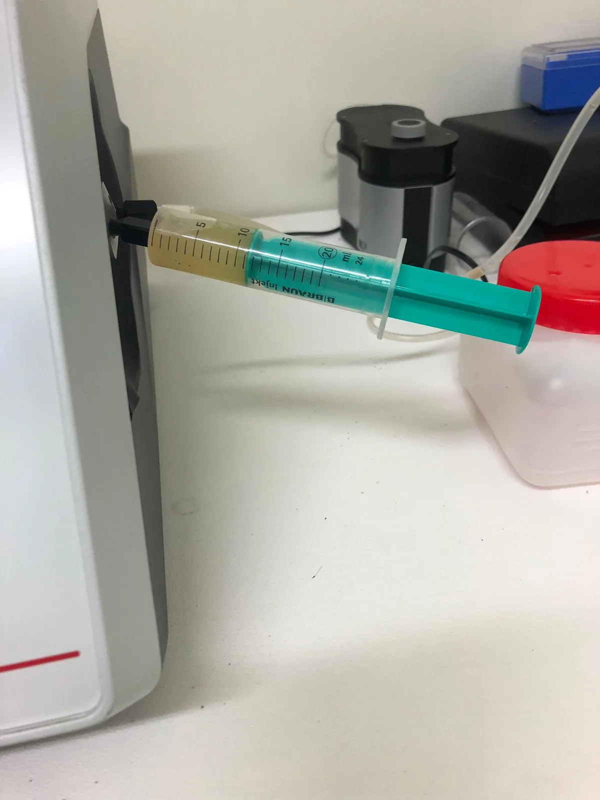 Seringue de moût injectée dans l'analyseur de laboratoire pour mesurer sucres, acidité, pH et azote assimilable