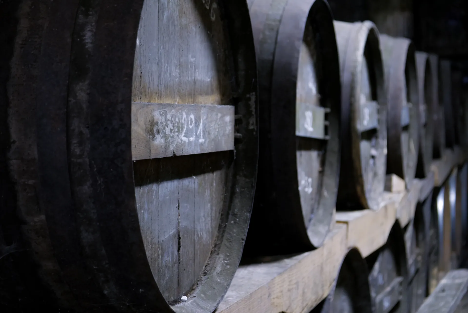 Barriques d'eaux-de-vie numérotées dans la pénombre du chai du domaine