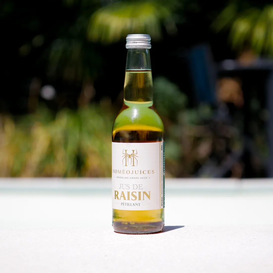 Botella de zumo de uva blanco espumoso «Homéojuices», de color amarillo pálido
